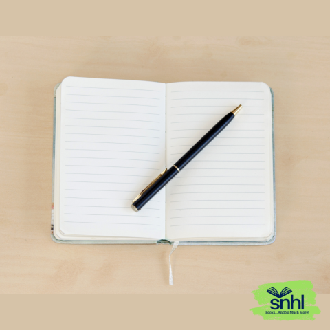 Open lined writing journal with pen lying across it